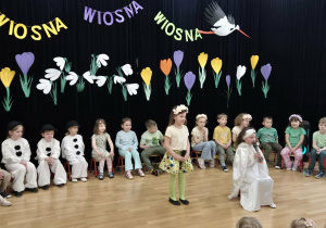 Dzieci w różnych przebraniach na tle wiosennej dekoracji