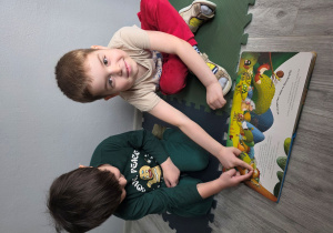 Remek i Dominik wskazują bohaterów bajki.