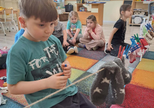 Dzieci dobierają skarpetki i zawieszają na sznurku.