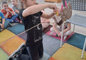 Dzieci dobierają skarpetki i zawieszają na sznurku.