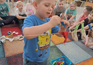 Dzieci dobierają skarpetki i zawieszają na sznurku.