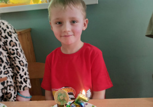 chłopiec siedzi przed babeczką