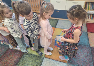 dziewczynka częstuje dzieci cukierkami