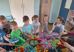 dzieci trzymają kwiaty ustawieni w kole