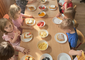 Dzieci zjadają udekorowane gofry.