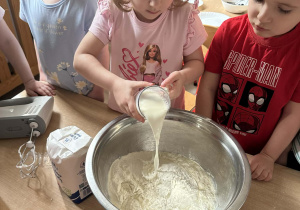 Zoja wlewa do miski szklankę mleka