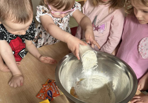 Gosia wsypuje do miski szklankę mąki