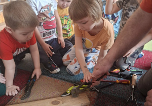 chłopiec wyciąga wbity gwóźdź