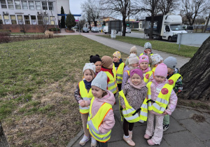 Dzieci stoją obok trawnika pełnego krokusów