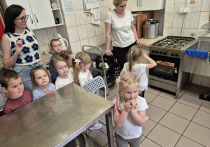 Dzieci w przedszkolnej kuchni w towarzystwie nauczycielki i kucharki