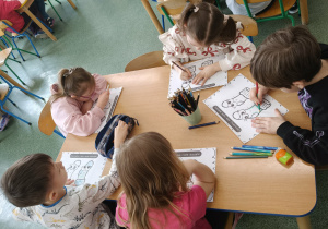 Dzieci podczas pracy przy stolikach.