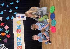 Hania B. odszukuje piłki w worku za pomocą dotyku.