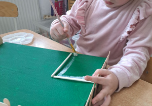 Daria wykonuje element makiety wiejskiego podwórka.