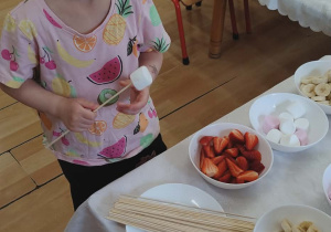 Dziewczynka szykuje szaszłyki.