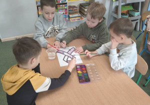 Dzieci wykonują pracę plastyczną.