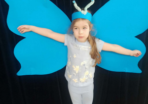 dziecko pozuje do zdjęcia na tle skrzydeł