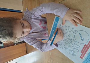 dziewczynka wykonuje pracę przy stole