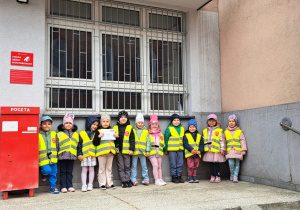 dzieci stoją przed pocztą