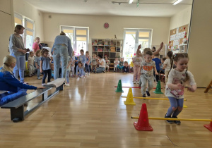 Dzieci w sali gimnastycznej wykonują różne ćwiczenia