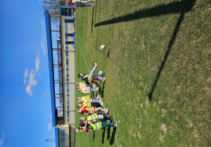 Chłopcy ćwiczą strzelanie piłką goli do bramki.