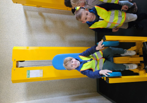 Chłopiec siedzi na przyrządzie do ćwiczeń.