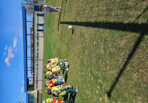 Dziewczynki ćwiczą strzelanie piłką goli do bramki.