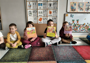 Dzieci trzymają plansze z zasadami bezpieczeństwa.