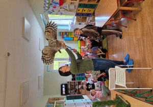 Pani Asia prezentuje dzieciom wielkość skrzydeł sowy.