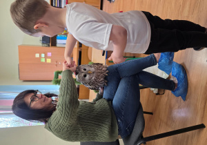 Oliwier dotyka sowę.