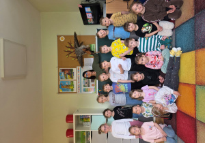 Wszystkie dzieci wraz z sową Ute i jej opiekunką pozują do wspólnego pamiątkowego zdjęcia.