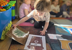 Dziewczynka segreguje śmieci.