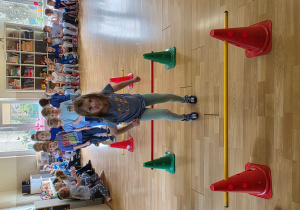 Dzieci w trakcie wykonywani konkurencji: przeskok obunóż przez laski gimnastyczne na różnych wysokościach