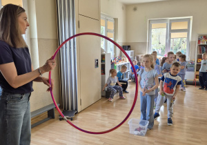 Dzieci w trakcie wykonywania konkurencji: rzucanie do hula hop.