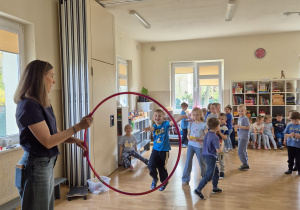 Dzieci w trakcie wykonywania konkurencji: rzucanie do hula hop.