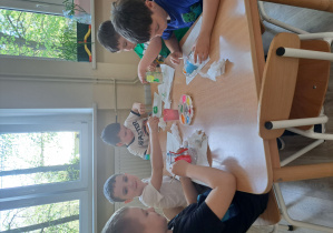 Dzieci malują farbami słoiki i butelki.