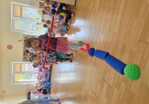 Przejście po ścieżce sensorycznej z laską gimnastyczną.