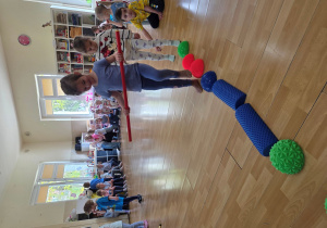 Przechodzenie po ścieżce sensorycznej z laską gimnastyczną.