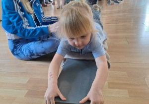 Przeciąganie po ławeczce gimnastycznej.