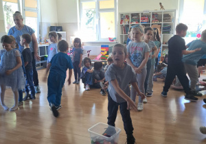Dzieci w trakcie wykonywania konkurencji: rzucania woreczkiem do hula hop.