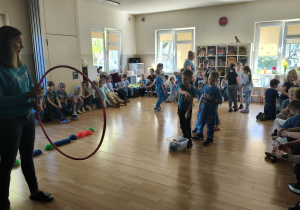 Dzieci w trakcie wykonywania konkurencji: rzucanie woreczkiem do hula hop.