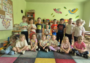 Dzieci w sali przedszkolnej pozują do zdjęcia