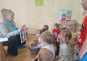Dzieci słuchają historii powstania pisma Braille’a.