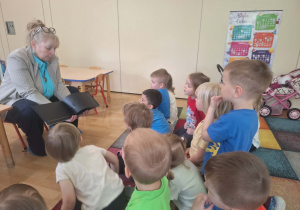 Dzieci oglądają książkę napisaną jezykiem Braille'a.