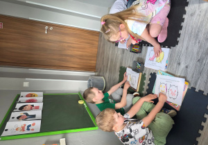 Dzieci wypełniają kartę pracy.