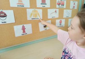 dziewczynka wskazuje obrazek z kombinezonem