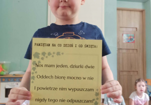 chłopiec trzyma kartkę z wierszem
