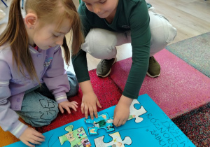 Dzieci umieszczają puzzle na drzewie różnorowności