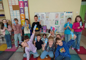 Dzieci pozują do zdjęcia z zakładkami do książek