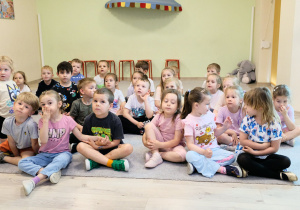 Dzieci siedzą na dywanie