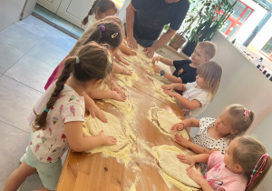 dzieci przygotowują ciasto na pizzę